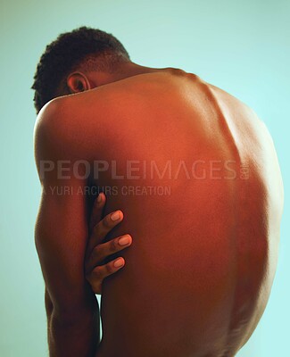 Buy stock photo Rearview shot of a man posing shirtless against a blue background