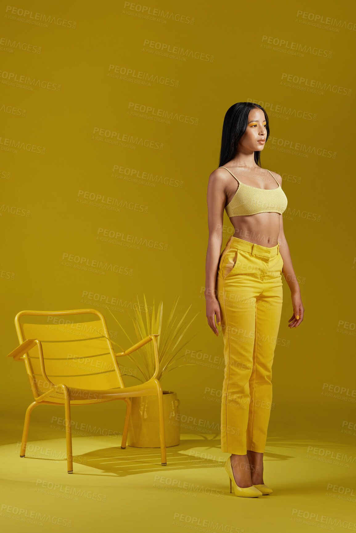 Buy stock photo Studio shot of a young woman dressed in stylish yellow clothes against a yellow background