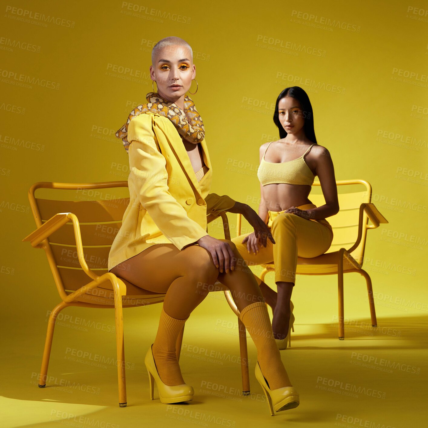 Buy stock photo Shot of two women dressed in stylish yellow clothes against a yellow background