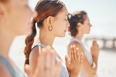 Buy stock photo Women friends meditation while training yoga exercise on the beach. Group of zen female athlete working out outside with inner peace, balance and getting healthy or wellness on a fitness lifestyle