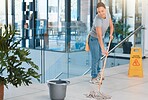 Cleaning service, office building or woman mopping floor with warning sign for job safety compliance. Bucket, bacteria or girl cleaner working on wet floor for dirty, messy or dusty tiles on ground