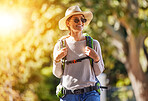 Nature, adventure and woman hiking in a forest for outdoor exercise, wellness and fresh air. Happy, smile and female trekking or walking in a green garden with a backpack and sunglasses in Canada.