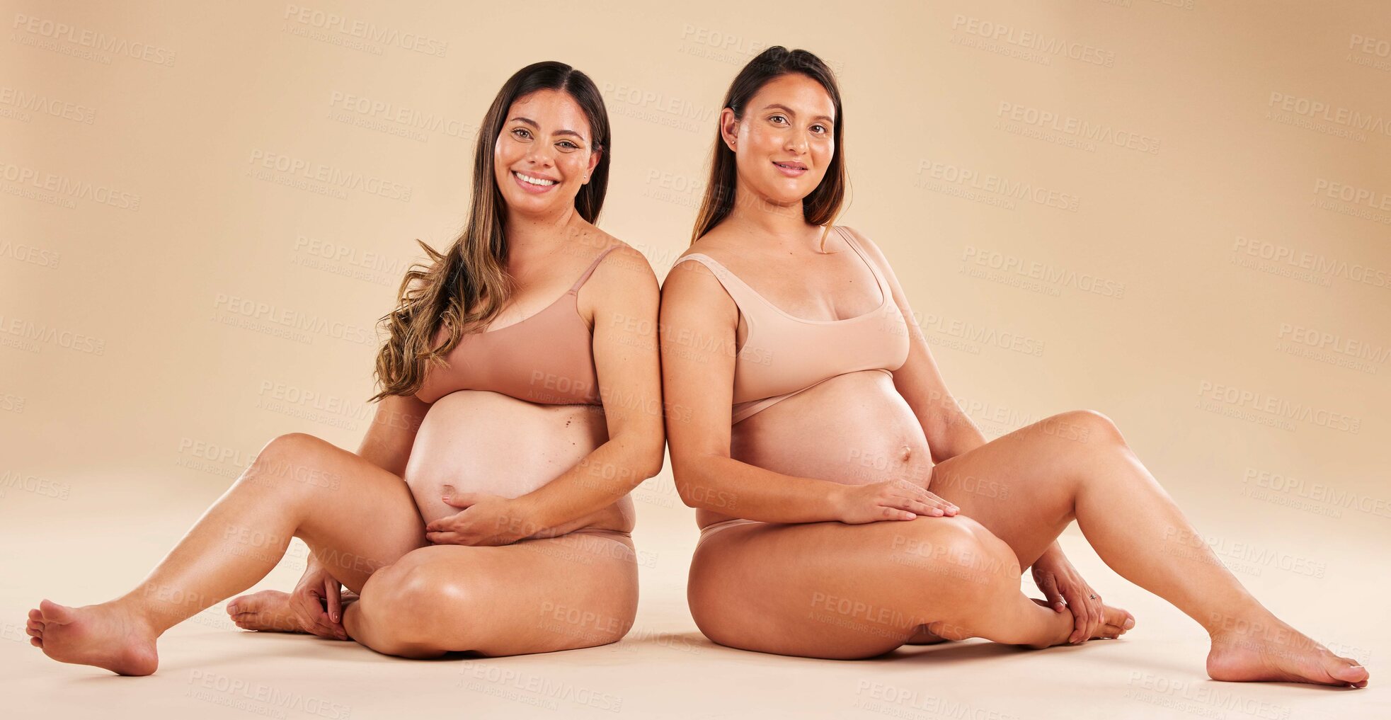 Buy stock photo Women, portrait or sitting with pregnant stomach, tummy growth progress or baby healthcare wellness on studio background. Smile, happy or friends in pregnancy underwear for solidarity support or love