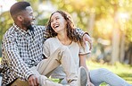 Happy, relax and interracial couple at a park for a date, quality time and bonding in Australia. Summer, love and black man and a woman in nature, laughing and talking in a relationship together