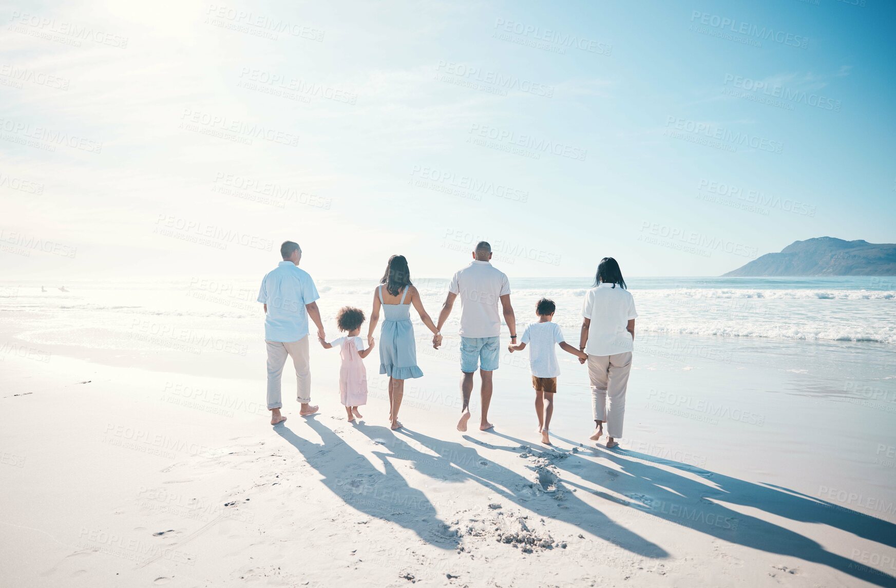 Buy stock photo Travel, beach and family walking on sand together at the sea or ocean bonding for love, care and happiness. Happy, sun and parents with children or kids and grandparents on a holiday for freedom