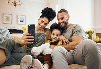 Buy stock photo Interracial parents, child and selfie on sofa, smile and hug for love, bonding and memory on web blog. Mom, dad and kid for photography, profile picture and happy for social media app in family house