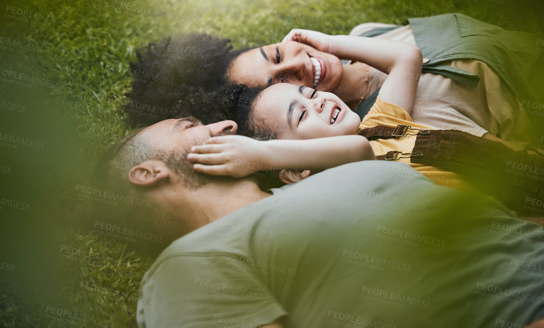 Buy stock photo Care, happy and a family lying on the grass in nature for bonding, laughing and comfort. Love, smile and an interracial, father, mother and boy kid in a garden or backyard with an embrace together