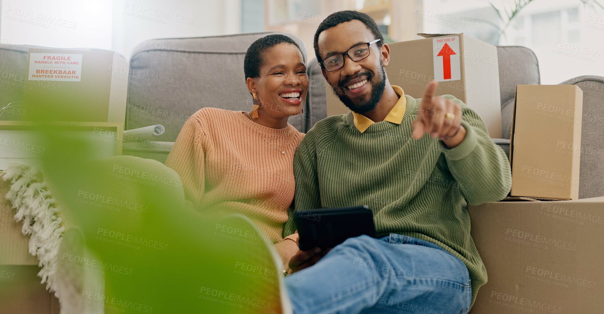 Buy stock photo African couple, pointing and new home with tablet, boxes and thinking with discussion, decision and choice. Black woman, man and floor for planning, moving or chat for real estate, property or house