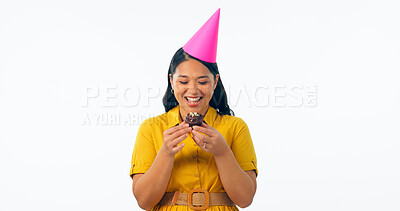 Buy stock photo Birthday party, chocolate and an asian woman eating a cupcake in studio isolated on a transparent background for celebration. Smile, hat and a happy young person with a dessert or snack at an event