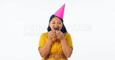 Buy stock photo Birthday, party and an asian woman eating a cupcake in studio isolated on a white background for celebration. Smile, hat and a happy young person with a chocolate dessert or snack at an event