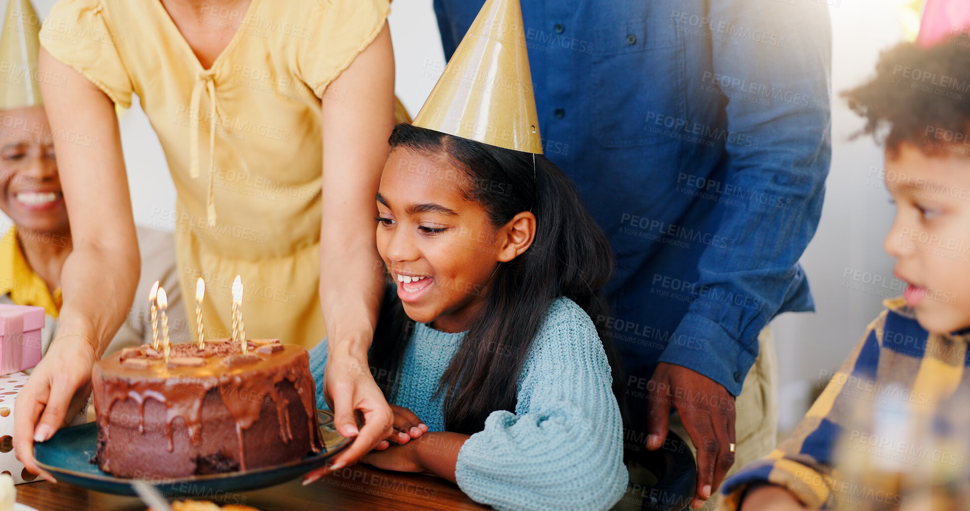 Buy stock photo Cake, smile and family at birthday party celebration together at modern house with candles and hat. Happy, excited and young children with parents and grandparents for sweet dessert at home.