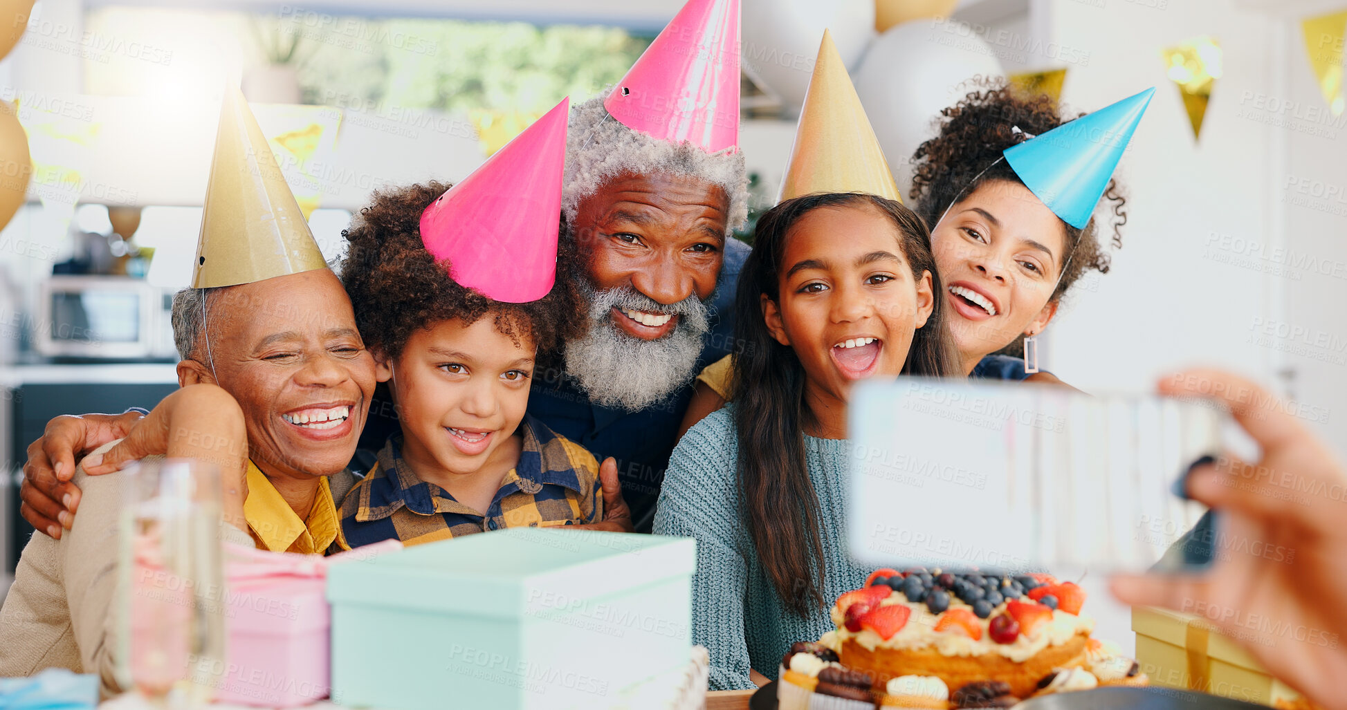 Buy stock photo Happy birthday, phone and family in celebration for memory or picture together at home. Excited people or group smile for photography, capture or social media while bonding at party or event at house