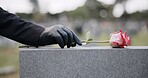 Funeral, cemetery and person with rose on tombstone for remembrance, ceremony and memorial service. Depression, sadness and hands with flower on gravestone for mourning, grief and loss in graveyard