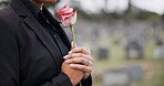 Funeral, cemetery and person with rose sad for remembrance, burial ceremony and memorial service. Depression, death and woman with flower on gravestone for mourning, grief and loss in graveyard