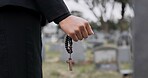 Rosary, death or hand cemetery for funeral. spiritual service or grave visit to repsect the Christian religion. Mourning, goodbye or closeup of person outside in graveyard for grief, loss or farewell