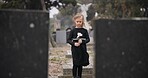 Sad, death or kid in cemetery for funeral. spiritual service or grave visit for respect in Christian religion. Mourning, tomb or depressed girl child outside in graveyard for grief, loss or farewell