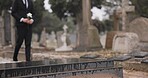 Funeral, walking in cemetery and man with flower for remembrance, burial ceremony and memorial service. Depression, death and sad person with rose for mourning, grief or loss in graveyard for respect