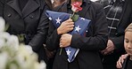 Funeral, graveyard and woman with American flag for veteran for respect, ceremony and memorial service. Family, depression and sad people with flower in cemetery for military, army and soldier hero