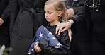 Funeral, cemetery and girl with American flag for veteran for respect, ceremony and memorial service. Family, depression and sad child by coffin in graveyard mourning military, army and soldier hero