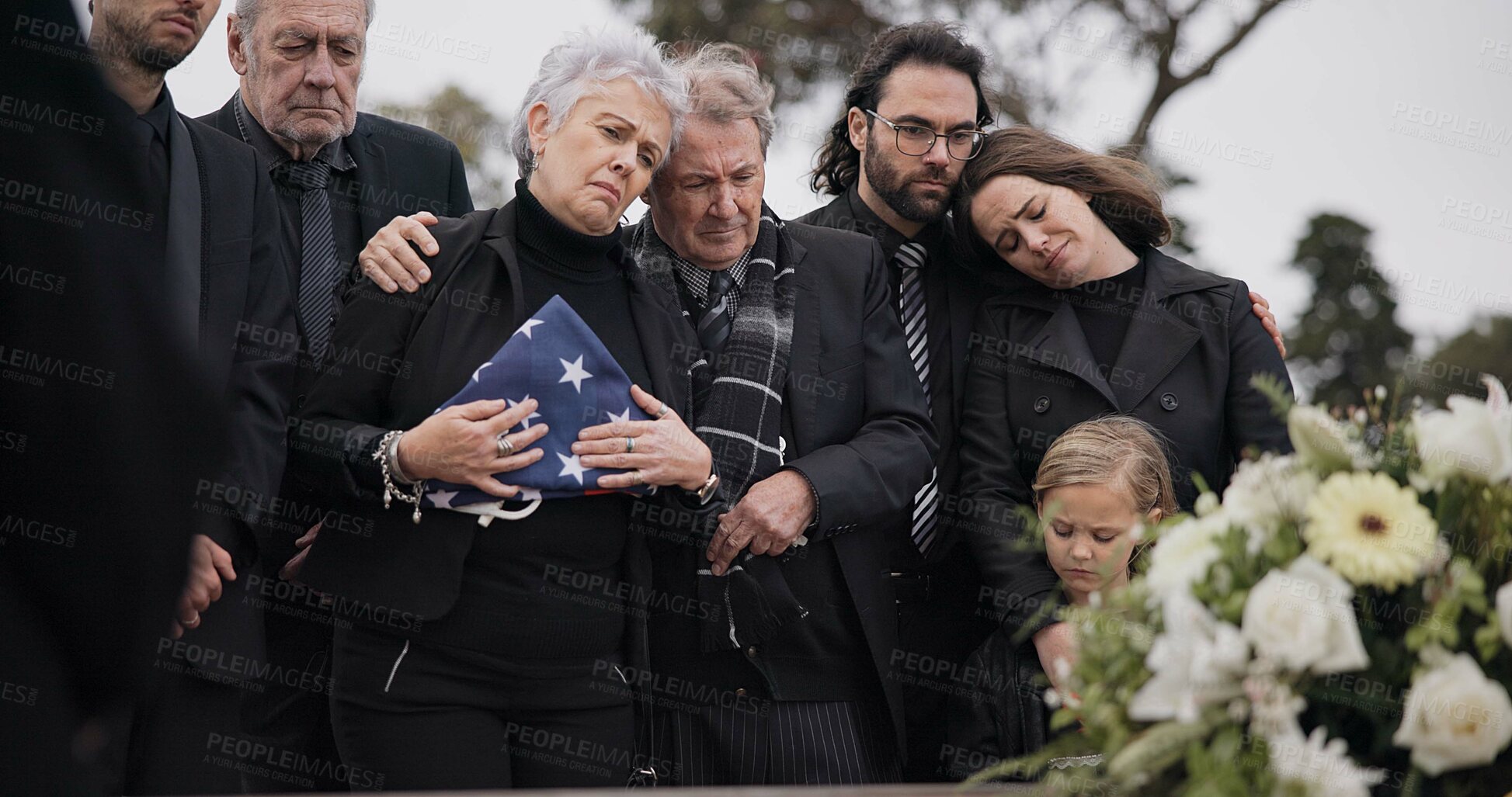 Buy stock photo Funeral, cemetery and family with American flag for soldier for respect, ceremony and memorial service. Sad, depression and people by coffin in graveyard mourning military, army and veteran hero