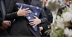 Hands, american flag and death with a person at a funeral, mourning a loss in grief at a graveyard. War, cemetery and an army wife at a memorial service to say goodbye to a fallen soldier closeup