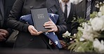 Hands, american flag and bible with a person at a funeral, grieving a loss at a graveyard. War, cemetery and death with an army wife at a memorial service to say goodbye to a fallen soldier closeup