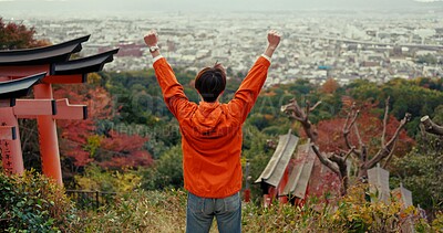 Man, fist celebration and mountain with view, city and torii gates at Fushimi Inari shrine for shinto religion. Person, hiking and cheers by trees, pillar or achievement on spiritual journey in Kyoto