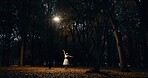 Ballet, dance and woman outdoor at night in Japan with street light, trees and creative art. Ballerina, performance and talent in dark Kyoto forest, woods or garden with spotlight