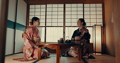 Women in traditional Japanese tea house, kimono and relax with conversation, respect and service. Friends at calm tearoom together with matcha drink, zen culture and ritual at table for ceremony.