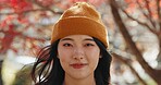 Japanese woman, portrait and smile in forest with red leaves, trees or nature for adventure in autumn. Girl, person and happy with headshot, outdoor or vacation in woods, park or environment in Tokyo