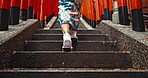 Woman, shinto culture or walk by stairs in japan, spiritual path or indigenous religion in kimono. Person, traditional clothes or worship in peace, respect or back by Fushimi Inari Taisha in kyoto