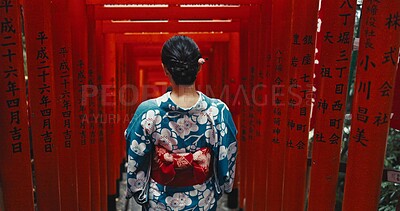 Woman, shinto religion and back by gates in japan, spiritual path and indigenous culture in kimono. Person, traditional clothes or worship in peace, respect or beauty by Fushimi Inari Taisha in kyoto