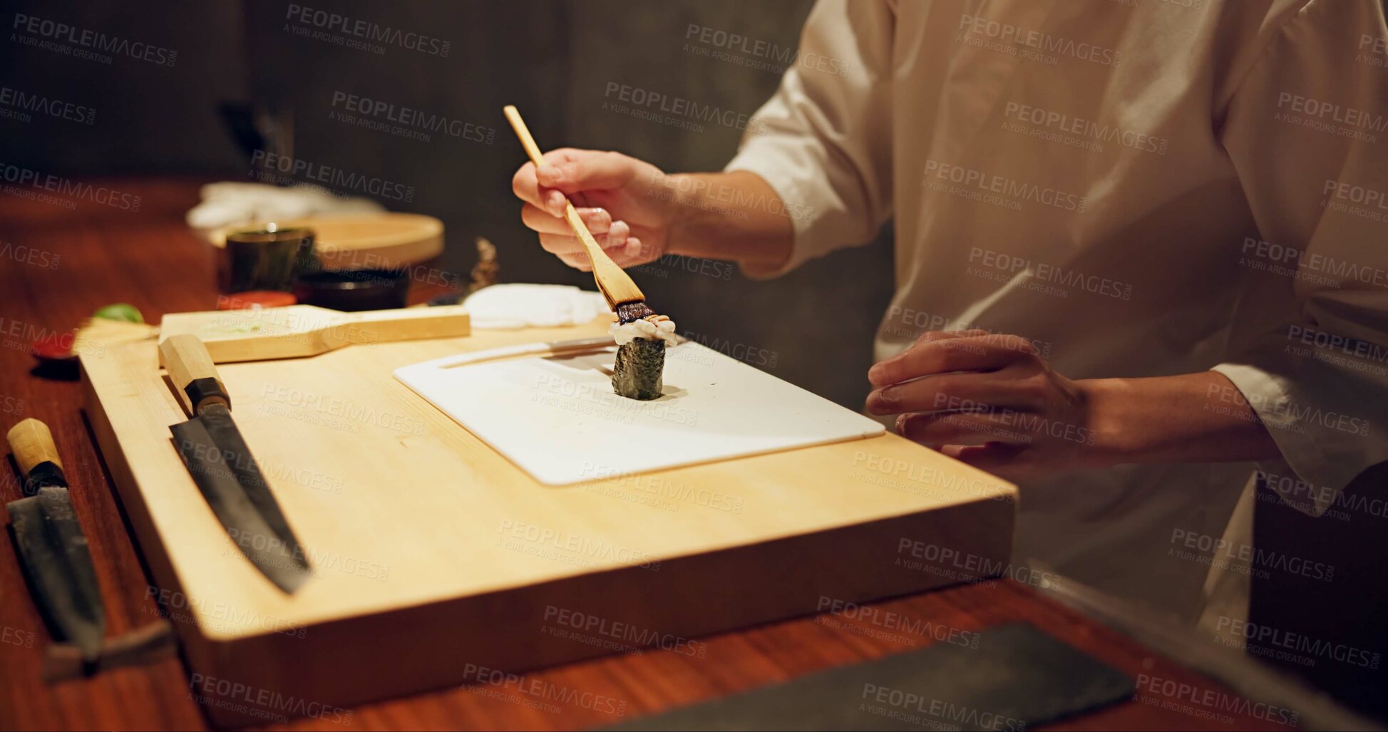 Buy stock photo Hands, food and sushi with cook in restaurant for traditional Japanese cuisine or dish closeup. Kitchen, table for seafood preparation and professional chef working with gourmet recipe ingredients