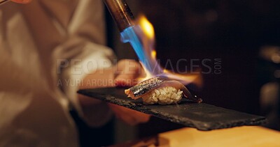 Buy stock photo Hand, sushi and fire with chef in kitchen of restaurant for luxury or traditional cuisine closeup. Food, blow torch and cooking with person flame grilling fish or salmon for Japanese seafood meal