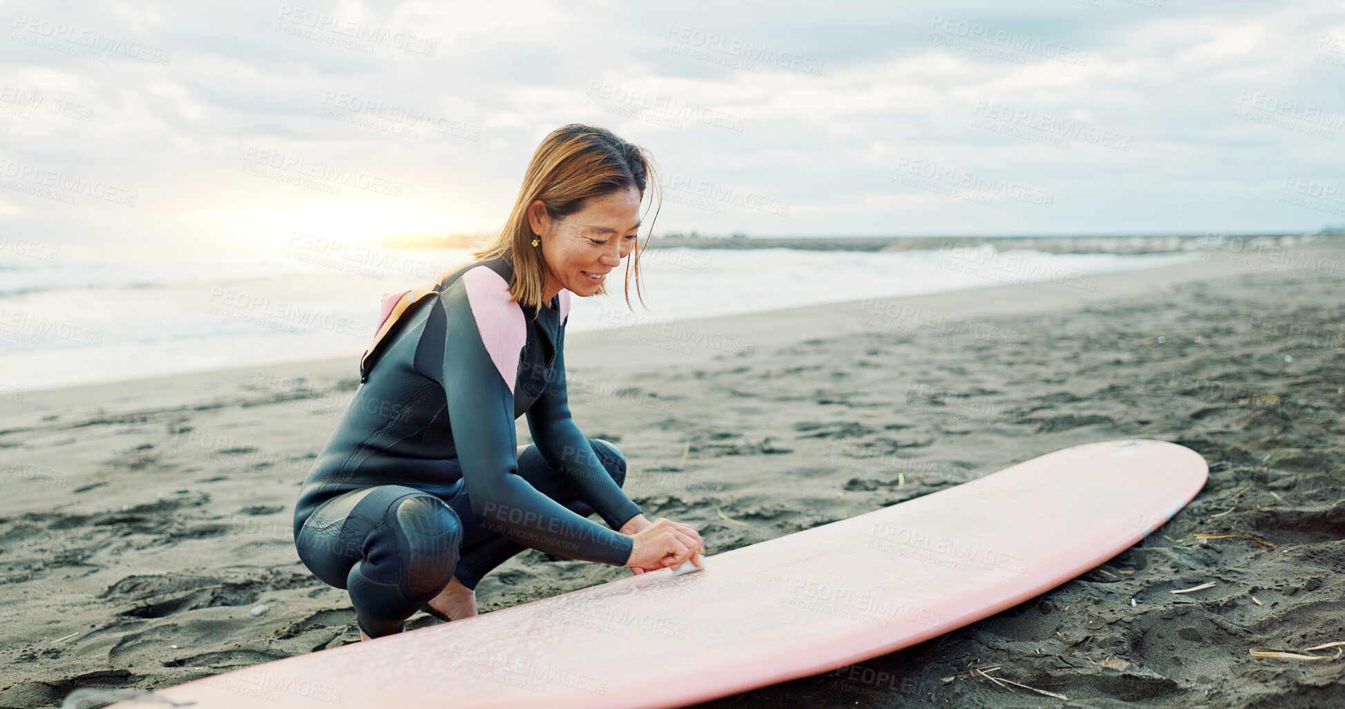 Buy stock photo Surfing, beach and woman with wax for surfboard for water sports, fitness and freedom by ocean. Nature, travel and happy Japanese person on sand for wellness on holiday, vacation and adventure by sea