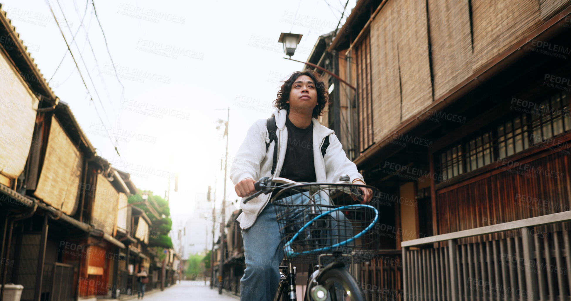 Buy stock photo Bike, travel and man riding by building for exercise or transportation to college academy. Fitness, backpack and young male student driving a bicycle to university for carbon footprint by houses.