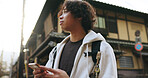 Japanese man, smartphone and travel in city with technology, gps and connection for destination directions. Young person, cellphone and mobile app in kyoto street and adventure on vacation in summer