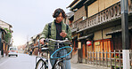 Bicycle, cellphone and man riding by building for exercise or transportation to college academy. Fitness, phone and young male student driving a bike to university for carbon footprint by houses.