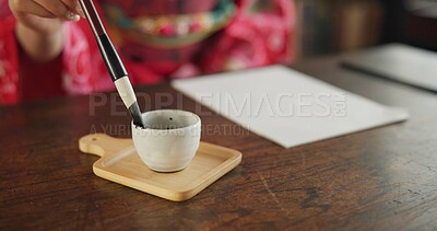 Buy stock photo Ink, writing and hands of Japanese woman in home for traditional script on paper, documents and page. Creative, culture and person with vintage paintbrush tools for calligraphy, font or text in house