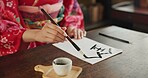 Ink, Japanese writing and hands of person in home for traditional script, paper and documents. Creative, Asian culture and person with vintage paintbrush tools for calligraphy, font and text in house