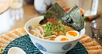 Ramen, food and restaurant bowl in Tokyo with traditional soup, meal and Japanese course on table. Egg, dinner and Asian cuisine in a cafeteria with a plate serving with noodles, tofu and seaweed