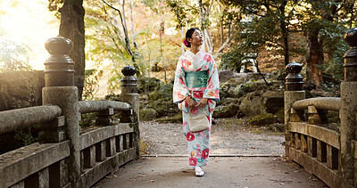 Walking, traditional and Japanese woman in park for wellness, fresh air and relax on bridge outdoors. Travel, culture and person in indigenous clothes, style and kimono on holiday, peace or adventure