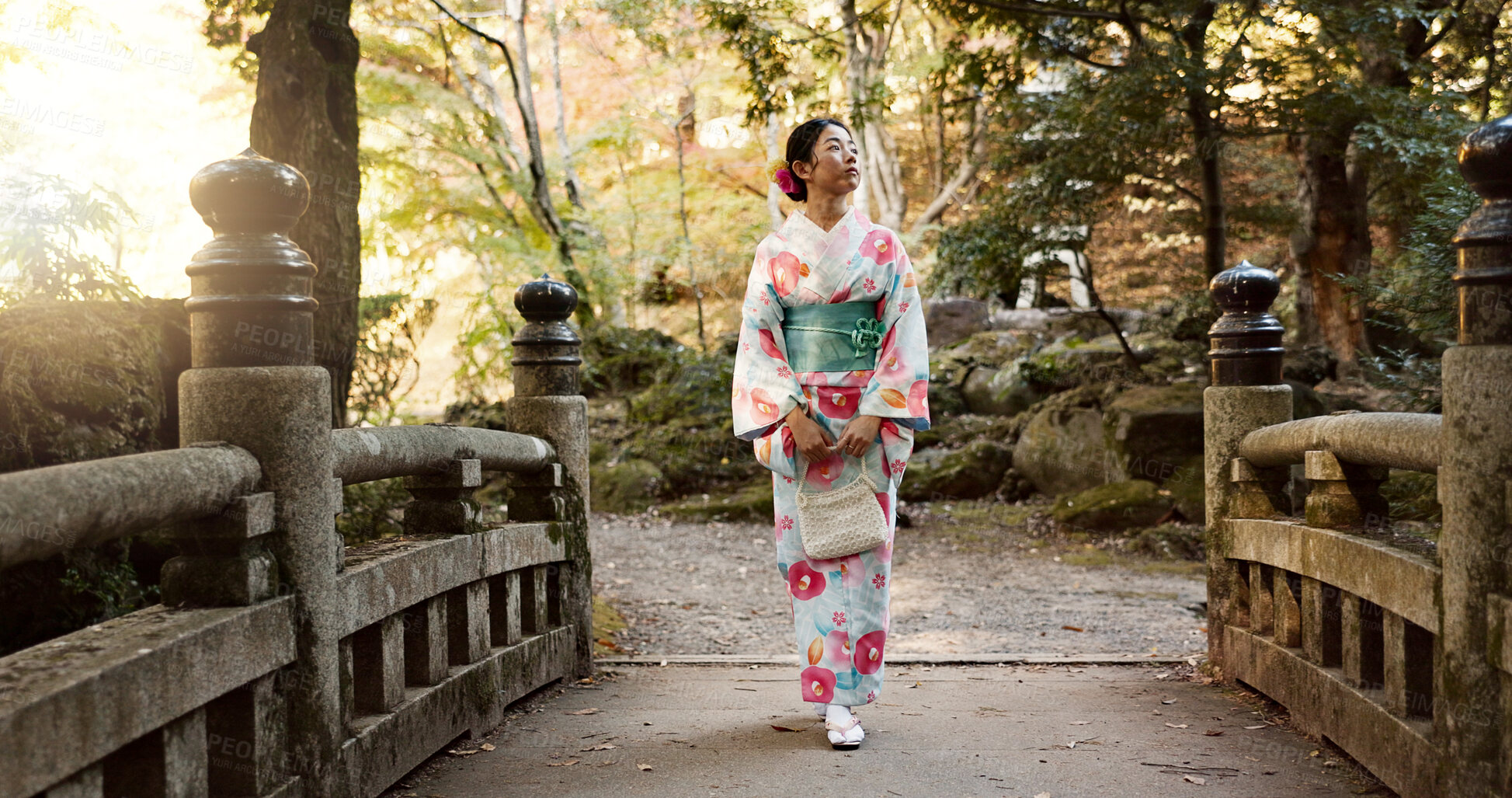 Buy stock photo Walking, traditional and Japanese woman in park for calm, fresh air and relax on bridge outdoors. Travel, culture and person in indigenous clothes, style and kimono on holiday, peace or thinking