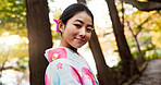 Japanese woman, portrait and kimono in forest with smile, pride and traditional clothes for culture on walk. Girl, person and happy with indigenous fashion, style or outdoor by trees, woods or nature