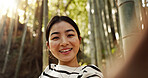 Japanese woman, portrait and selfie in forest with smile, pride and bamboo in bush for post on web blog. Girl, person and happy influencer on adventure, trekking or hiking by trees for social media