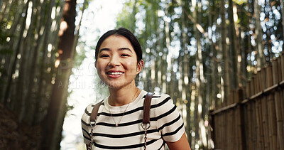 Buy stock photo Japanese woman, portrait and bamboo in forest with smile, pride and backpack for travel on holiday in bush. Girl, person and happy with hiking by plants, freedom and outdoor by trees, woods or nature