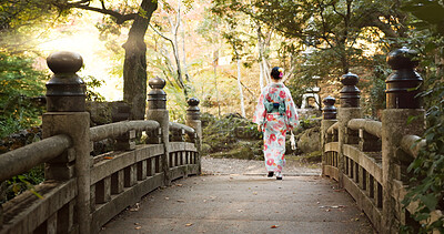 Bridge, culture and Japanese woman in park for wellness, fresh air and walking in nature. Travel, traditional and person in indigenous clothes, fashion and kimono outdoors for zen, calm and peace