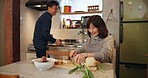 Cooking, conversation and Japanese couple in kitchen cutting vegetables for meal, dinner or lunch. Happy, talking and senior man and woman preparing food for supper together with produce at home.