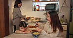 Family, Japanese and mother feeding girl in kitchen of home for growth, health or nutrition. Food, daughter eating in Tokyo apartment with parent and grandparent for diet or child development