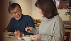 Japanese couple, food and home with conversation, love and bonding together with happiness, romance and smile. Apartment, old man or senior woman with healthy meal, nutrition and cheerful with dinner